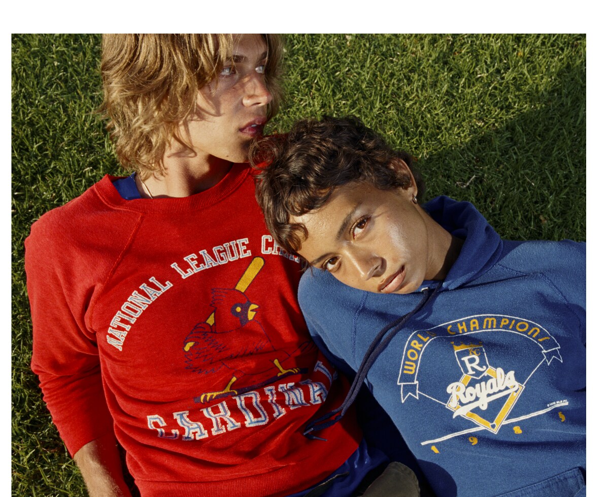 Two friends on the grass in vintage Cardinals and Royals sweatshirts